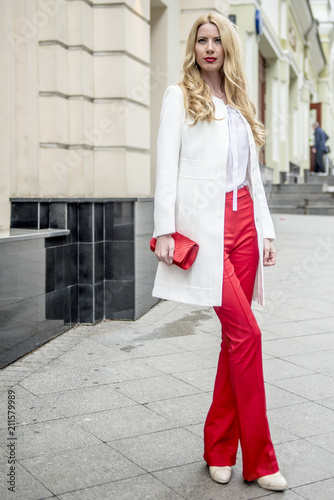 Fashionable young blonde in a spring fashionable suit and with a shopping bag in the center of Moscow
