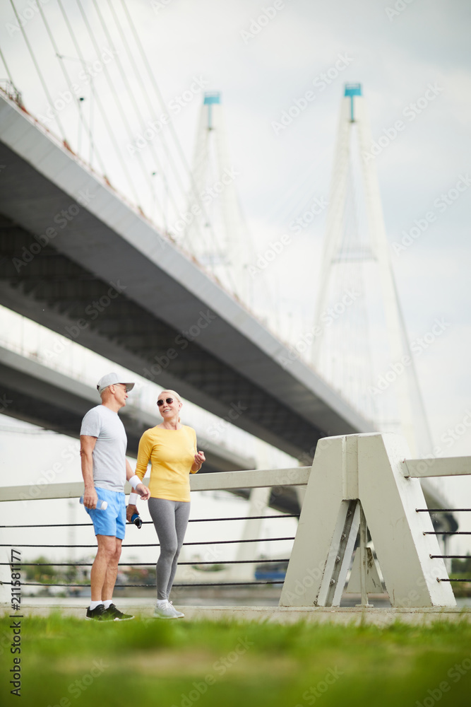 Mature couple looking at one another during outdoor training in urban environment