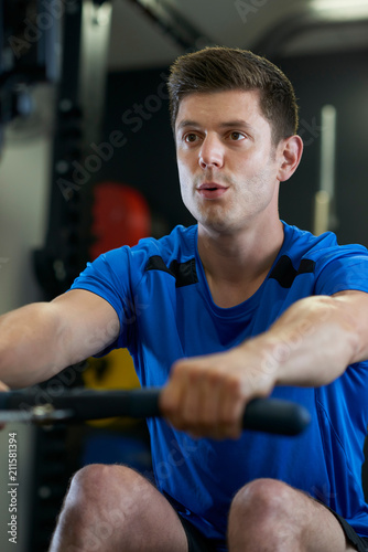 Man In Gym Exercising On Rowing Machine
