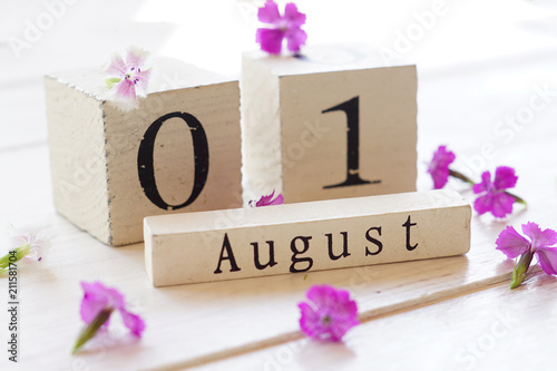 1 August, colorful background with cube wooden calendar and pink flowers