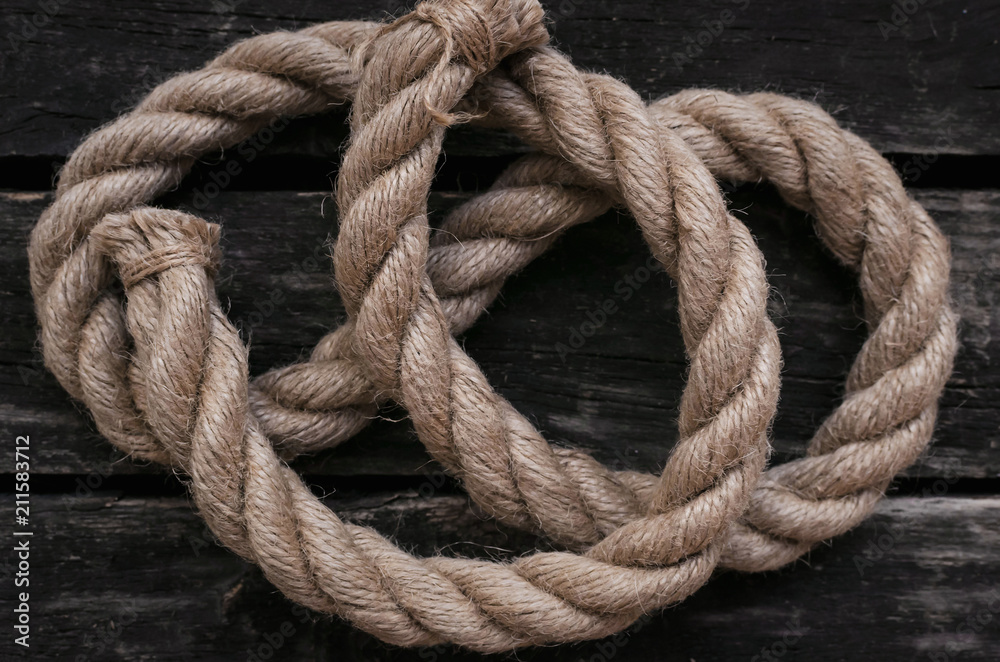 Moorings rope on aged wooden table background.