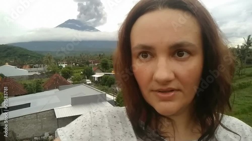 woman making selfie on cell phone, agung Volcano erupting january 2018 photo