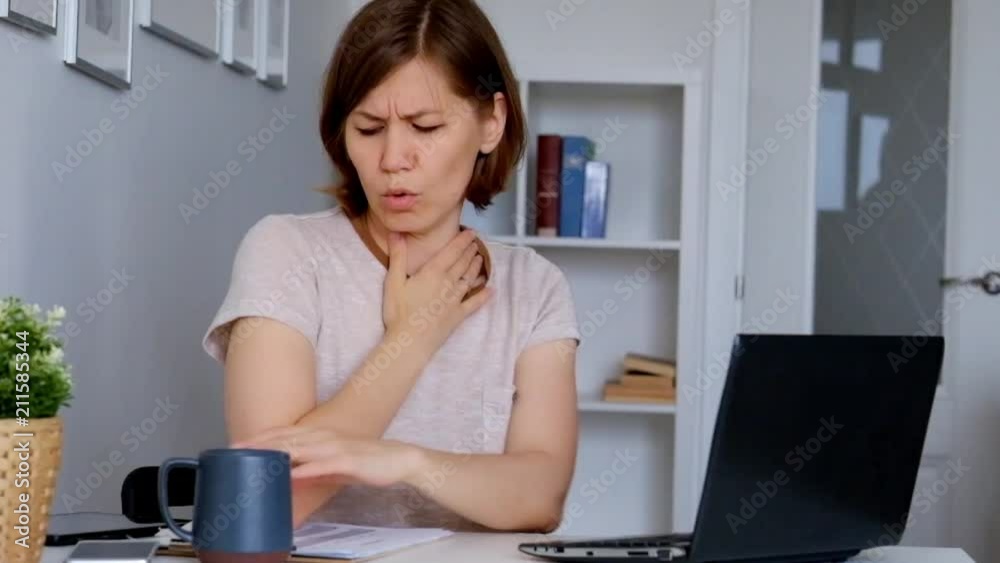 Woman working at home office, feeling ill and sneezing Woman working at home office, feeling ill and sneezing