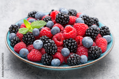 Fresh raspberries in a plate on a vintage background.