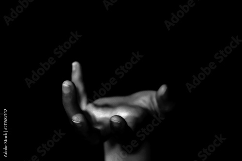 Hand of woman reaching out from the dark