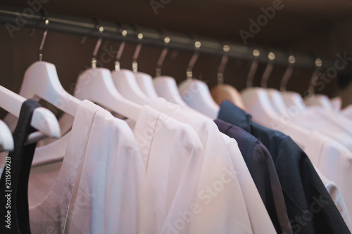Shirts hanging on rack in wardrobe. Selective focus.
