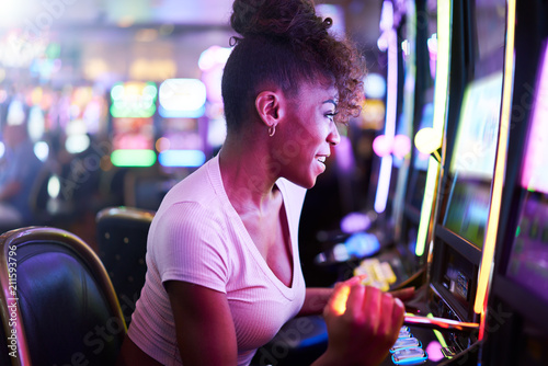 woman having fun playing slot machine at casino