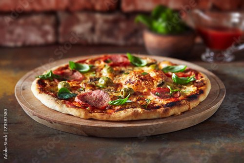 Foto Thin crust pizza with ham, cheese and olive