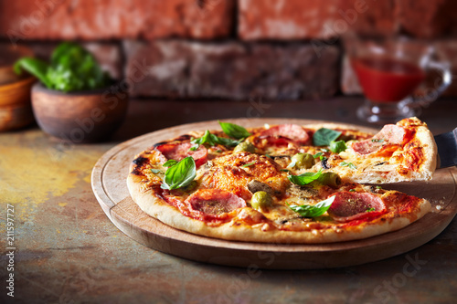 Thin crust pizza with ham, cheese and olive. Freshly baked pizza (from wood-fired oven). 