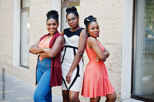 Three stylish african american womans posed at sunny summer day outdoor.