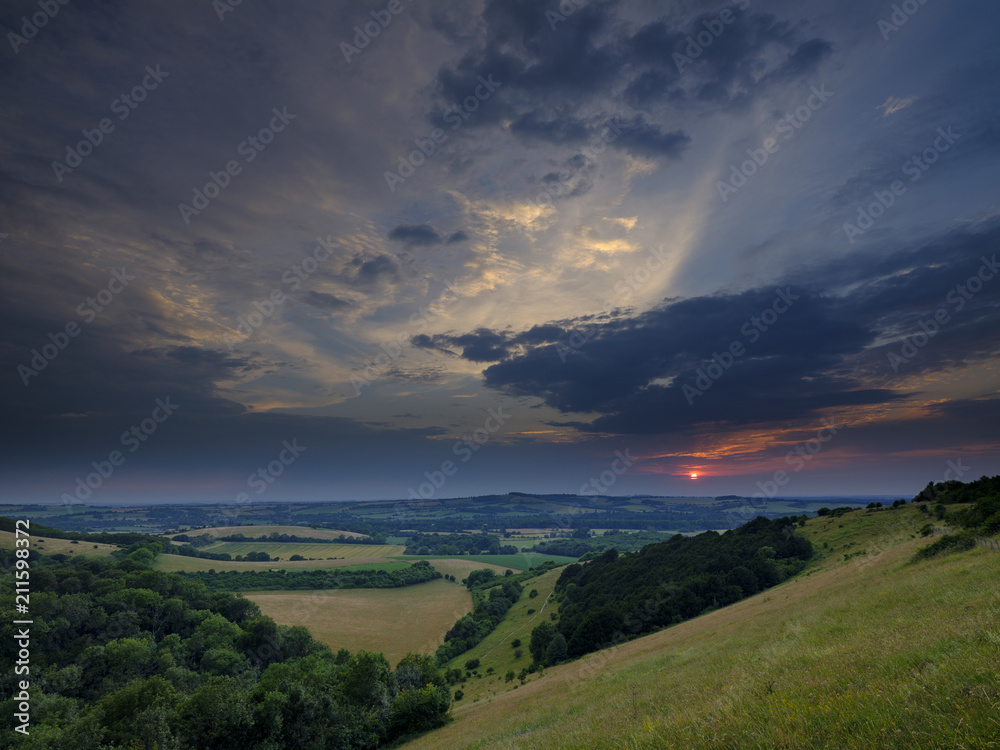 Dramatic summer sunset over Beacon Hill from near Old Winchester Hill on the South Downs, near Warnford in the Meon Valley in the South Downs National Park, Hampshire, UK Dramatic summer sunset over Beacon Hill from near Old Winchester Hill on the South Downs, near Warnford in the Meon Valley in the South Downs National Park, Hampshire, UK