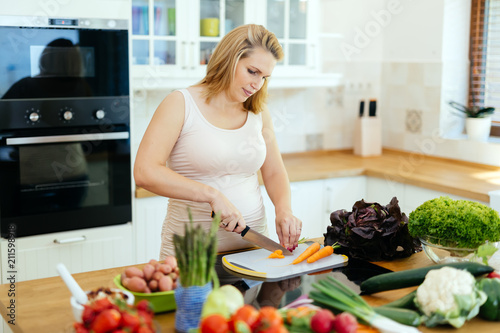 Beautiful pregnant woman preparing meal