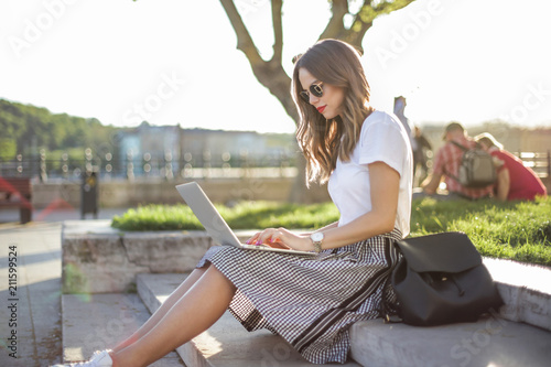 Girl with laptop sitting at the park