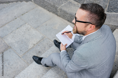 overhead view of businessman writing in planner © LIGHTFIELD STUDIOS