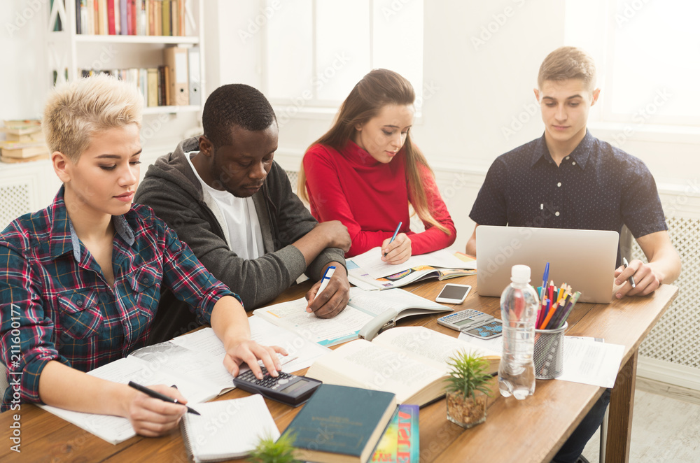 Group of diverse students studying at wooden table Group of diverse students studying at wooden table