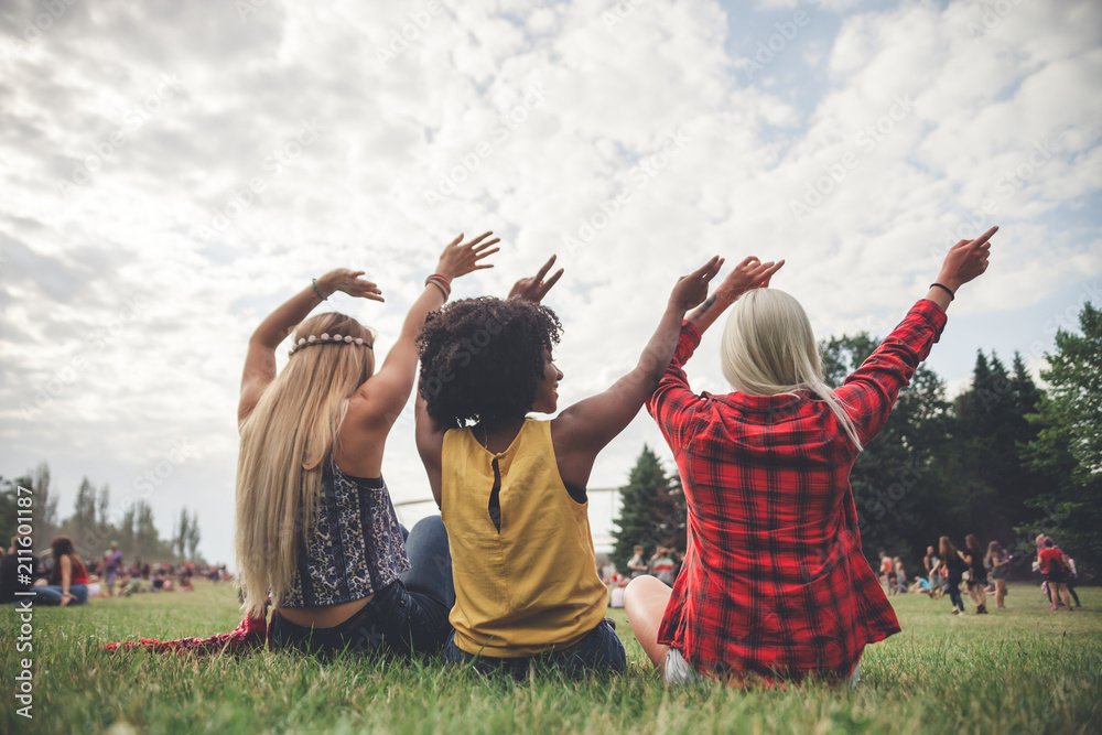 Φωτογραφία Group of friends at summer festival sitting on grass enjoying music