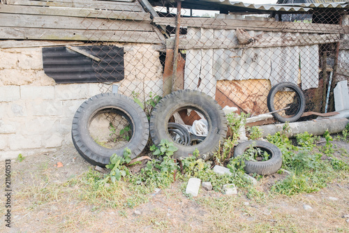 Old tire and breeding ground for mosquito. Remnants of broken pieces after the demolition of an old building. Street scene. Recycling industry. Ecology. photo