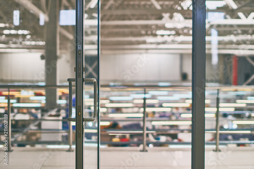 Open door in the modern office or shopping center in grey colors with bokeh background