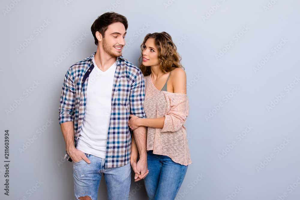 Portrait with copy space empty place of sensual cheerful couple cuddling looking at each other holding hands enjoying walking outdoor isolated on grey background Portrait with copy space empty place of sensual cheerful couple cuddling looking at each other holding hands enjoying walking outdoor isolated on grey background