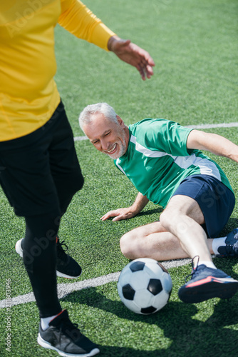 partial view of elderly men playing football on field