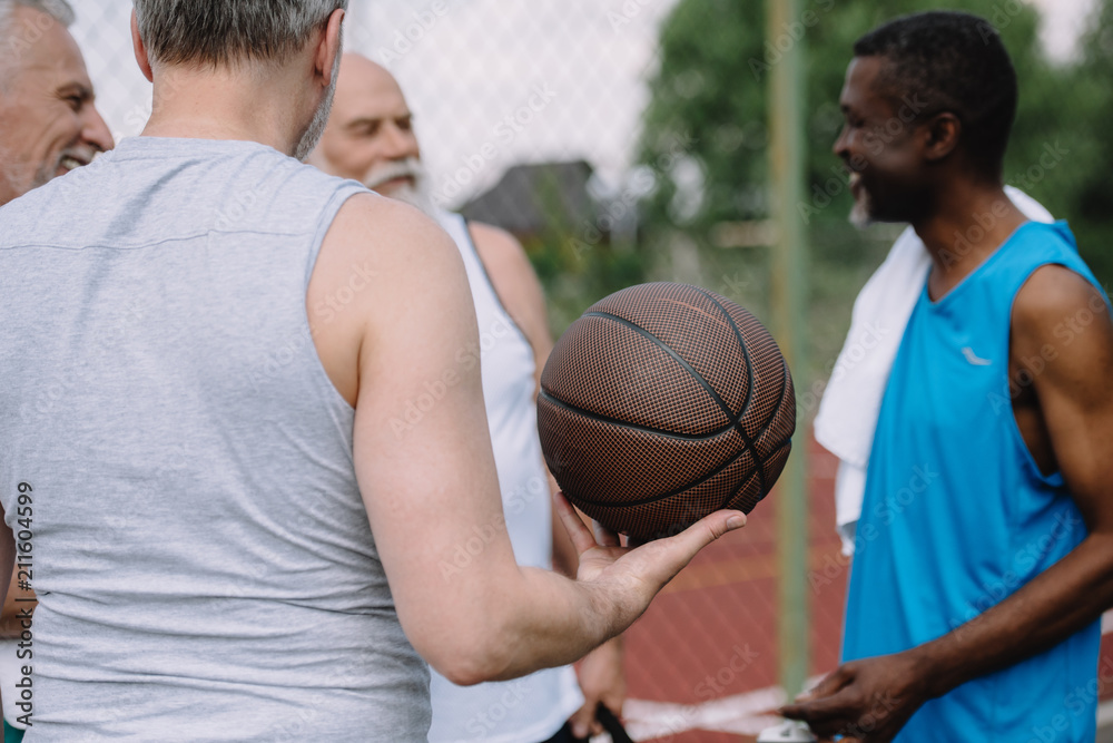 selective focus of group of multiracial old sportsmen with basketball ball on playground selective focus of group of multiracial old sportsmen with basketball ball on playground