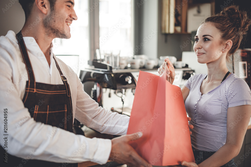 Happy customer taking paper bag after shopping at coffee shop Happy customer taking paper bag after shopping at coffee shop