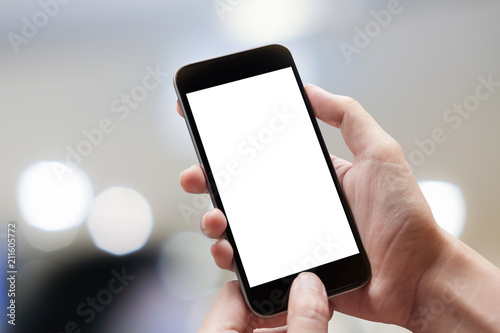 Woman hand holding smartphone with blur bokeh. Blank screen mobile phone for graphic display montage