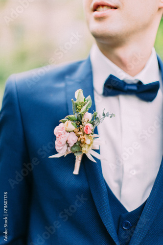 The boutonniere of roses on the jacket of the groom. photo