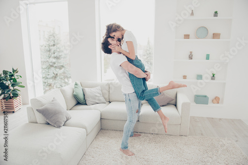 Full size portrait of lovely romantic partners in denim clothes enjoying holiday together in modern living room. Harmony idyllic leisure weekend concept
