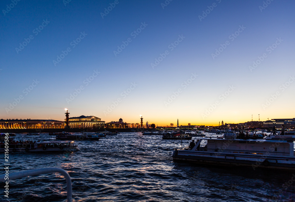 Many boats are on the Neva river in St. Petersburg in the evening before the fireworks