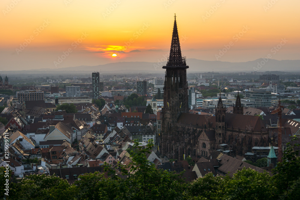 Germany, Ancient minster and houses of Freiburg im Breisgau in orange sunset light