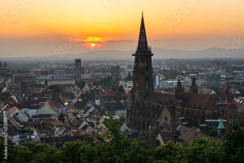 Germany, Ancient minster and houses of Freiburg im Breisgau in orange sunset light