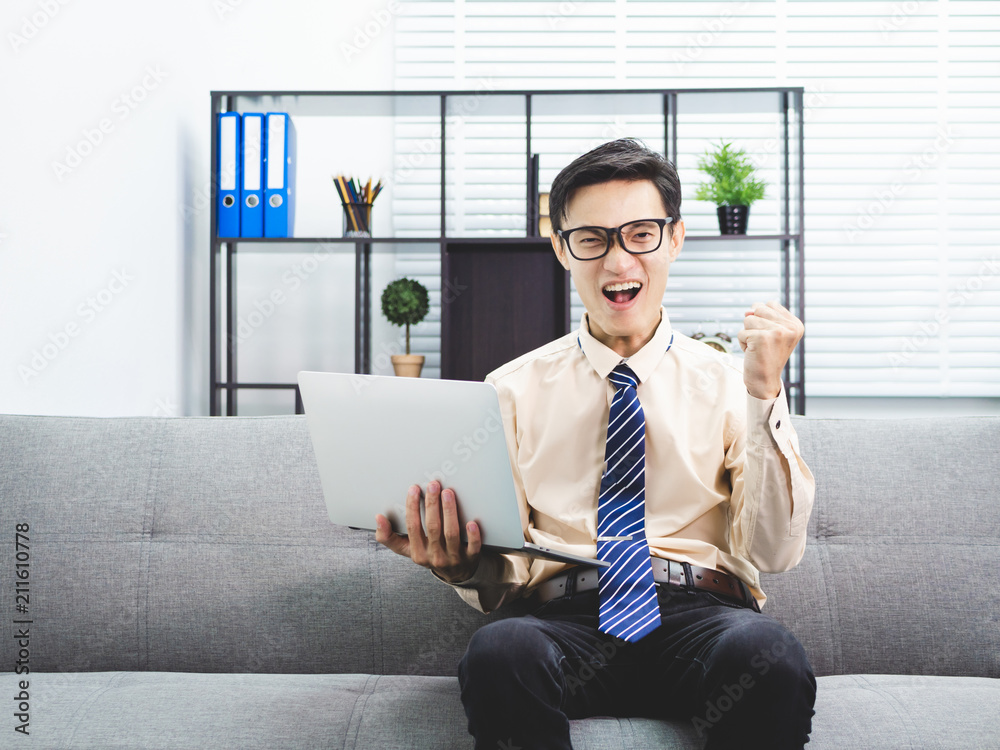 Young asian businessman smile successful sitting on sofa in office.