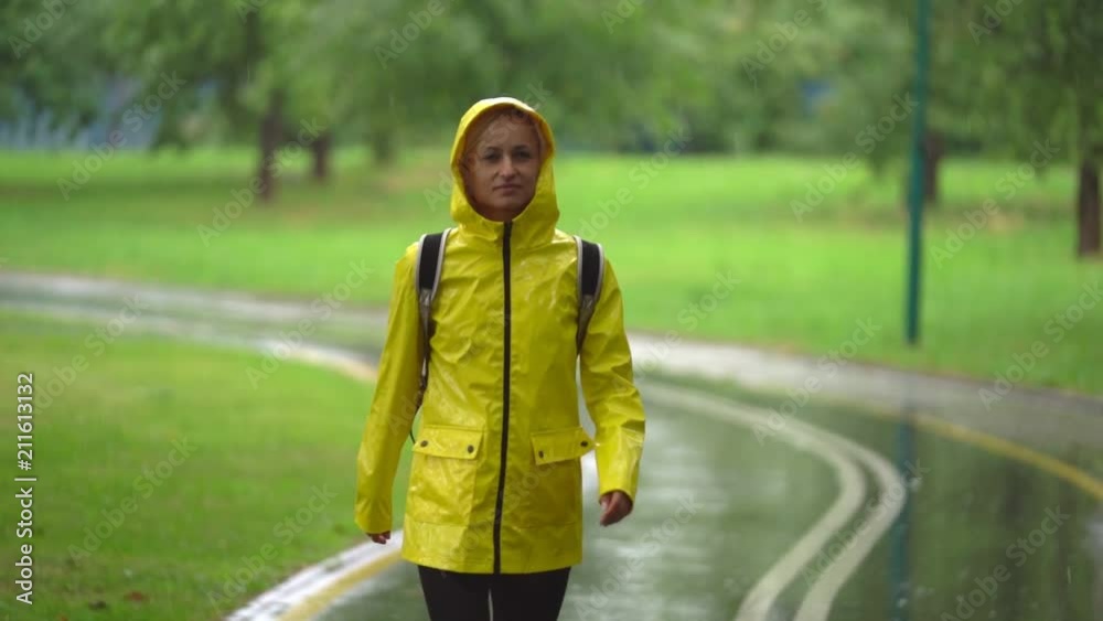 Young beautiful happy woman in yellow raincoat enjoying the rain. Young beautiful happy woman in yellow raincoat enjoying the rain.