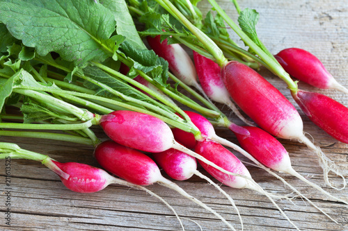 Fresh radishes with oblong root-crops on a wooden background. Organic food photo