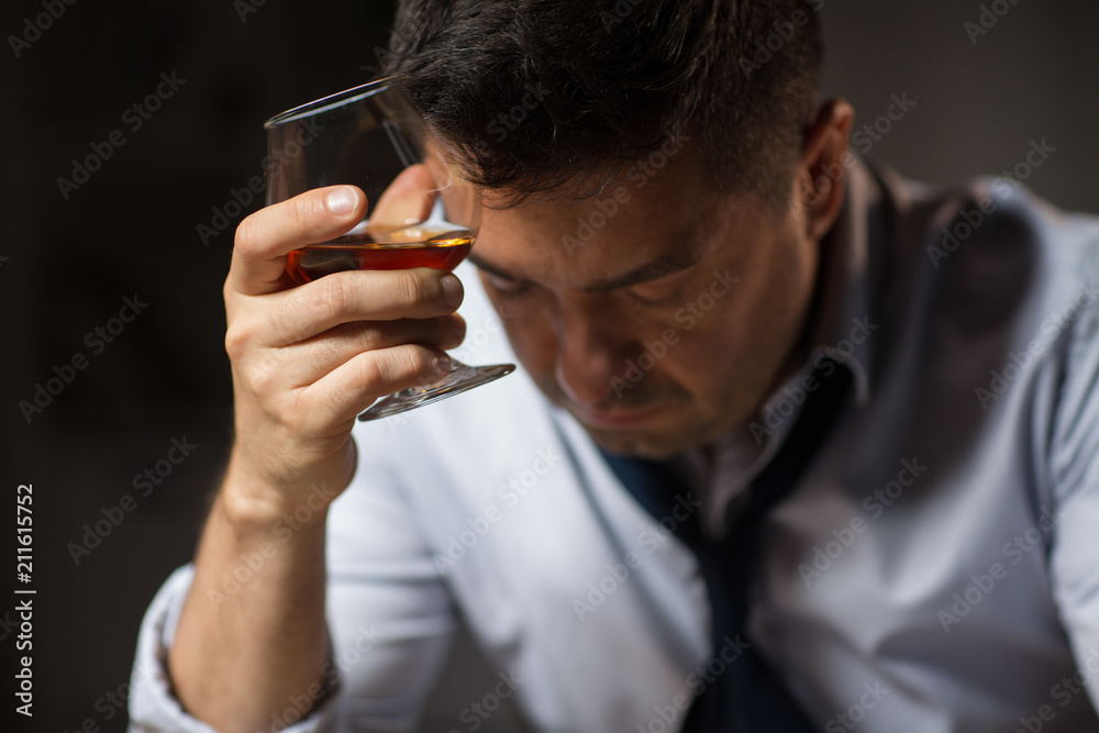 alcoholism, alcohol addiction and people concept - close up of male alcoholic drinking brandy at night alcoholism, alcohol addiction and people concept - close up of male alcoholic drinking brandy at night