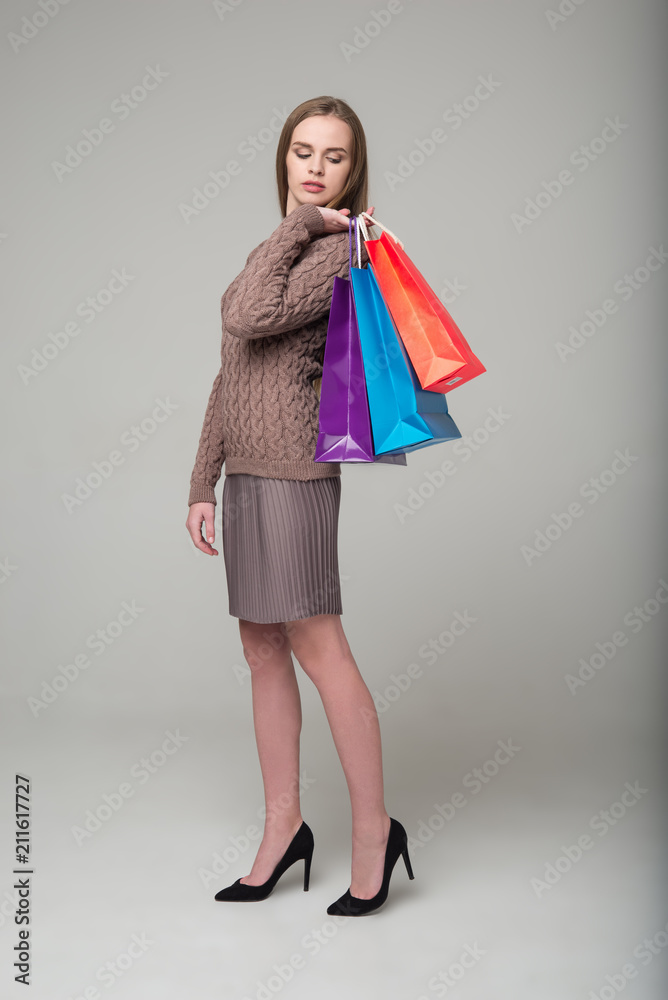 Blond girl in brown skirt and jamper with shopping bags Blond girl in brown skirt and jamper with shopping bags