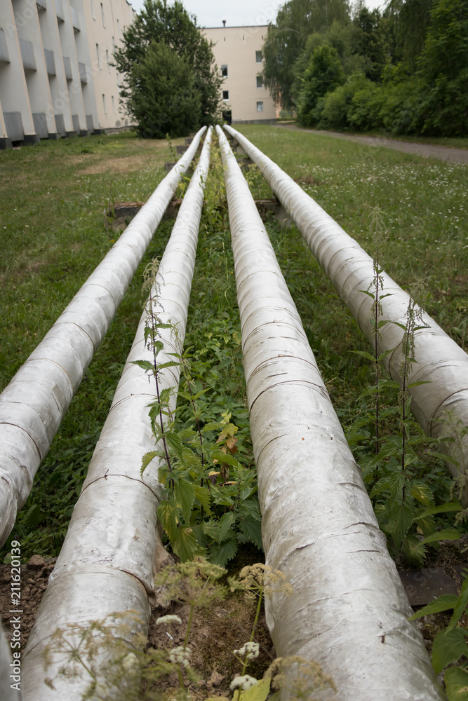 Laying of heat-insulated large diameter pipes for hot water supply during the construction of a residential area. Pipes are insulated with special materials. Are above the ground. Laying of heat-insulated large diameter pipes for hot water supply during the construction of a residential area. Pipes are insulated with special materials. Are above the ground.