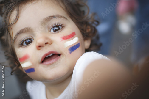 Kid fan with red, white and blue flag painted on face