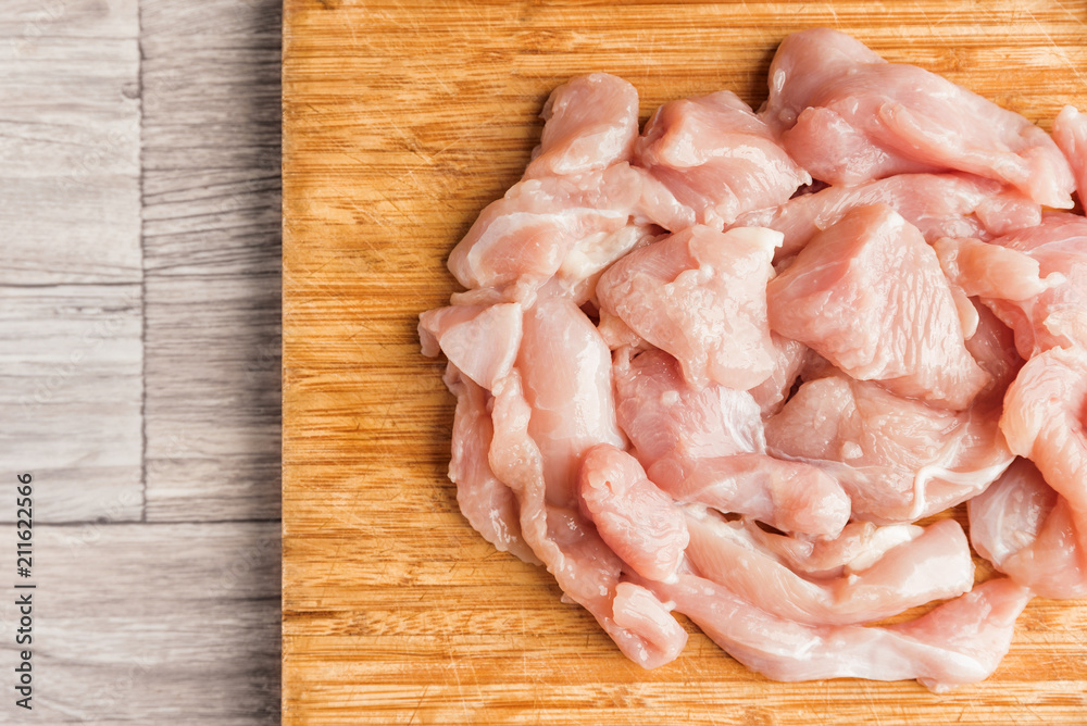 Fresh chicken fillet pieces on a wooden cutting board Fresh chicken fillet pieces on a wooden cutting board