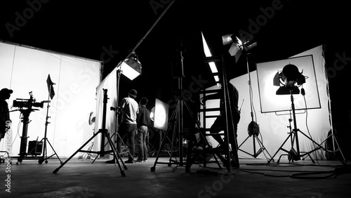 Behind the scenes of TV commercial movie film or video shooting production which crew team and camera man setting up green screen for chroma key technique in big studio. photo