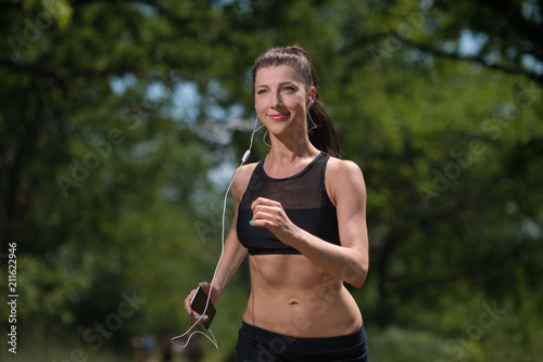 Girl athlete running in the woods, doing sports outdoors © Vladimir