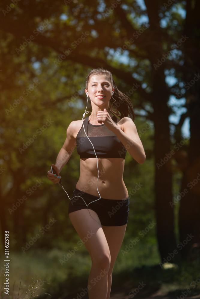 Girl athlete running in the woods, doing sports outdoors Girl athlete running in the woods, doing sports outdoors