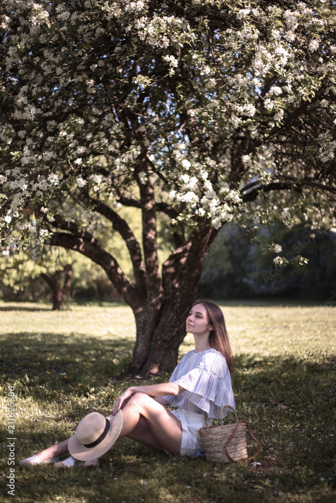 Pretty young woman in a summer garden, casual romantic style with hat Pretty young woman in a summer garden, casual romantic style with hat