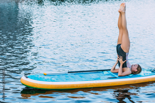 Woman on paddleboard with legs raised