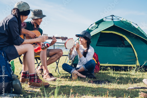 Youth friends camping together and funny playing music