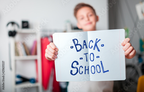 Teenage boy showing Back to School text and giving thumbs up
