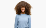 African american woman wearing a sweater with a happy and cool smile on face. Lucky person.