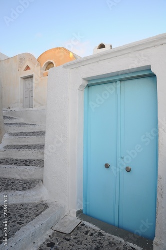 White architectures and blue doors above the volcanic caldera in the village of Oia in Santorini island, Greece
