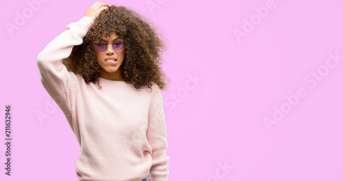 Photos African american woman wearing a pink sweater stressed with hand on head, shocked with shame and surprise face, angry and frustrated